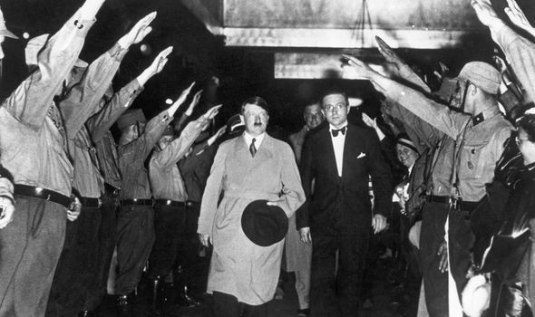 Hitler passe entre une double rangée d'hommes au garde-à-vous.