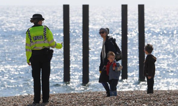 Une policière parle avec une famille sur une plage 