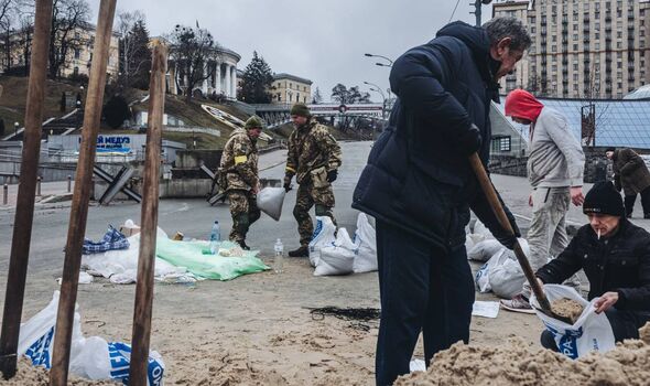 Des civils ukrainiens préparent des provisions à Kiev.