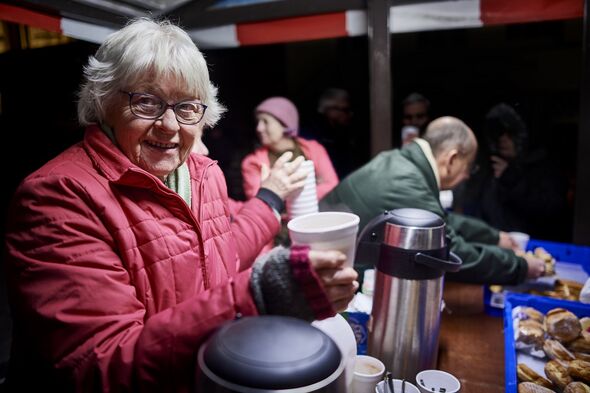 Une femme âgée fait du bénévolat dans une soupe populaire