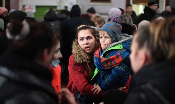 Une femme porte un enfant à la gare de Lviv, dans l'ouest de l'Ukraine