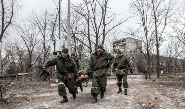Des soldats de la DNR (République populaire de Donetsk) courent avec une civière transportant un séparatiste blessé 