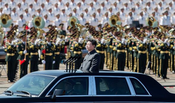 Xi Jinping se promène dans une voiture à toit ouvert devant la place Tiananmen et la Cité interdite lors d'une parade militaire.