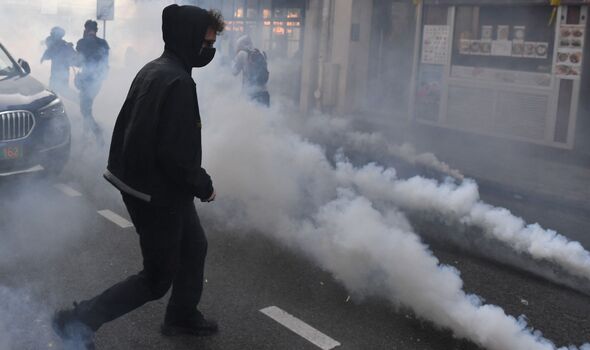 Des étudiants fuient les gaz lacrymogènes lancés par la police anti-émeute lors d'une manifestation devant La Sorbonne.
