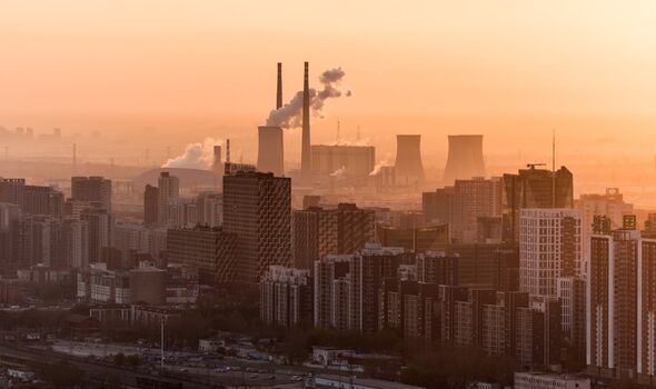 Pékin, vue surélevée de bâtiments et d'une usine avec de la fumée sortant de hautes cheminées.