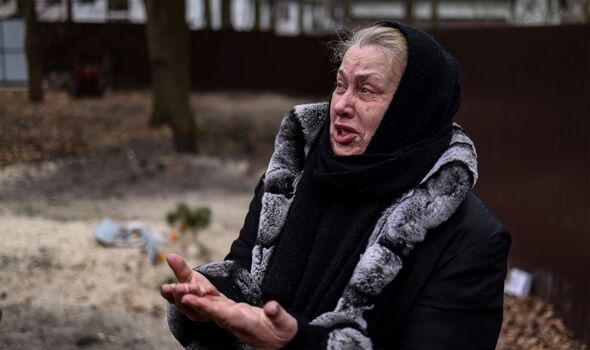 Tetiana Ustymenko, habitante de Buca, pleure sur la tombe de son fils, enterré dans le jardin de sa maison.