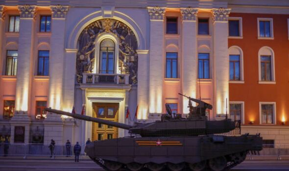 Un char russe à l'extérieur d'un immeuble chic avec des piliers.