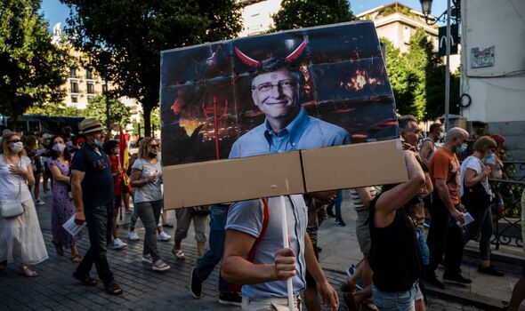 Homme portant une photo de Bill Gates lors d'une manifestation anti-vaccination.