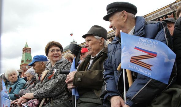 Des Russes agitent des drapeaux avec la lettre 'Z', symbole de l'offensive russe en Ukraine, lors du défilé de la Victoire.