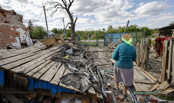 La citoyenne ukrainienne Nina est vue devant une maison détruite dans le village de Pidgayne alors que les attaques russes se poursuivent