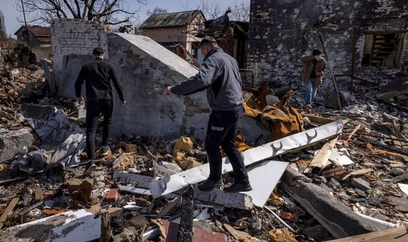 La police marche parmi les décombres d'une maison détruite dans le village de Bohdanivka