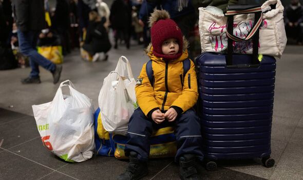 Un garçon attend avec sa mère l'arrivée en Pologne de personnes fuyant l'Ukraine déchirée par la guerre. 