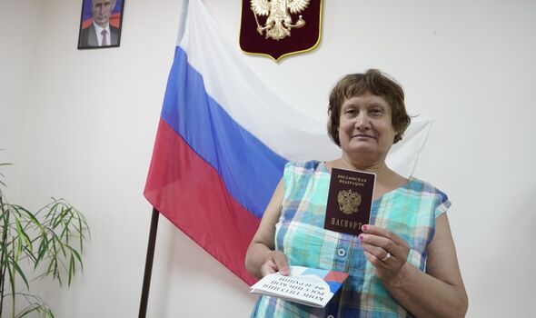 Une femme reçoit son passeport russe dans un centre de traitement en Ukraine