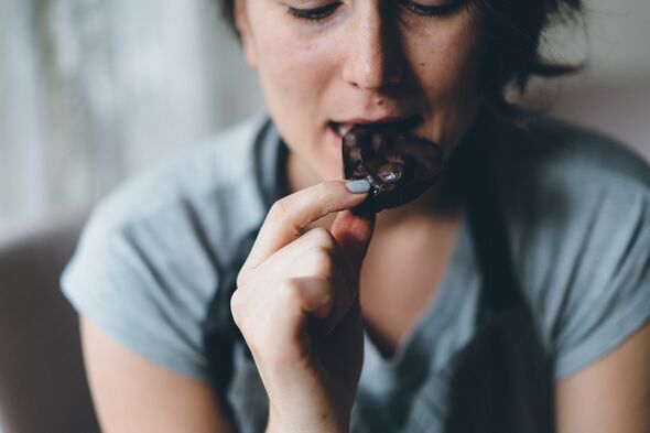 Une femme mange du chocolat