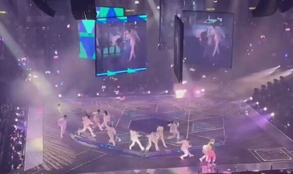 Des danseurs d'un boys band écrasés par un écran géant devant des milliers de personnes lors d'un concert.