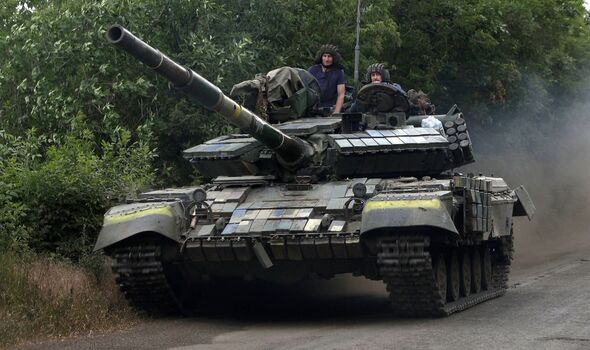 Des soldats ukrainiens montent sur un char sur une route de l'est de la région de Luhansk.