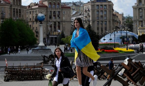 Femme avec le drapeau ukrainien à côté d'un char