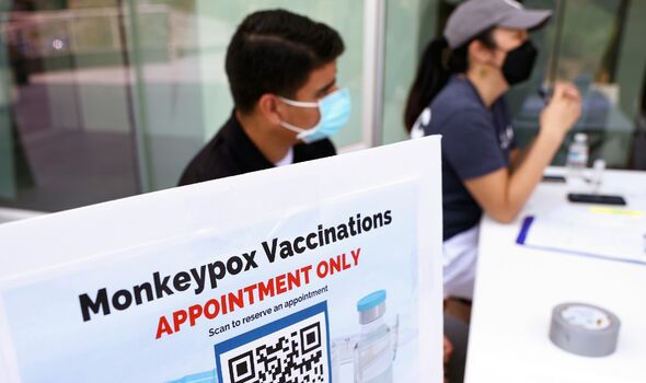 Des agents de santé sont assis à une table d'enregistrement dans une clinique éphémère de vaccination contre la variole du singe 