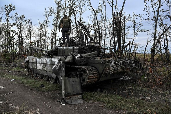 Le 11 septembre 2022, un soldat ukrainien debout sur un char russe abandonné près d'Izyum, dans la région de Kharkiv