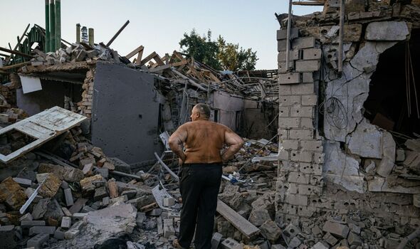 Homme en Ukraine près d'un bâtiment détruit