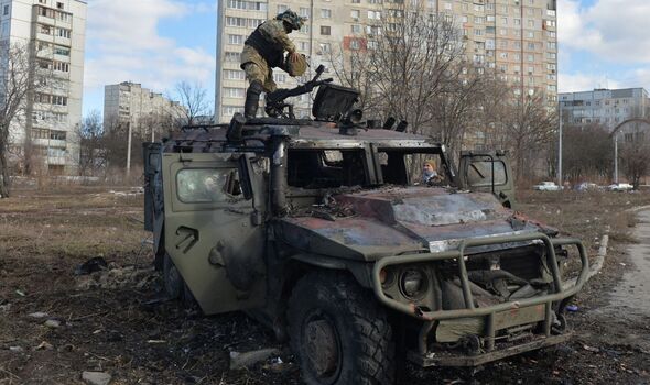 Soldat ukrainien au sommet d'un char russe détruit