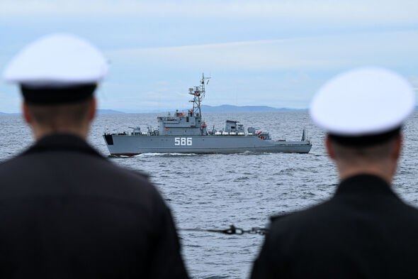 Une image de stock de marins russes regardant un navire de la marine russe.