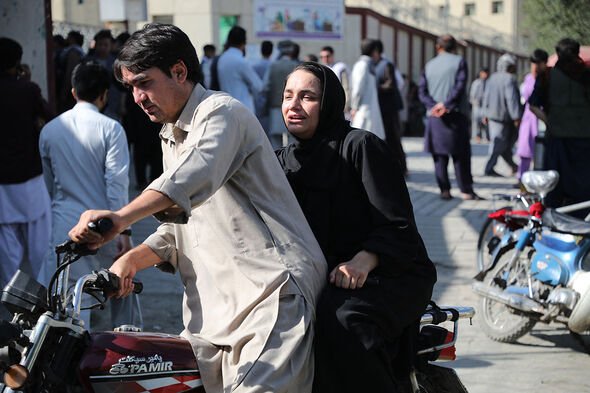 Une femme arrive sur une moto pour chercher un parent dans un hôpital de Kaboul le 30 septembre 2022 après une explosion dans un centre d'apprentissage dans le Dasht-e-Barchi.