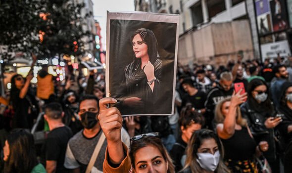 Un manifestant tient un portrait de Mahsa Amini 