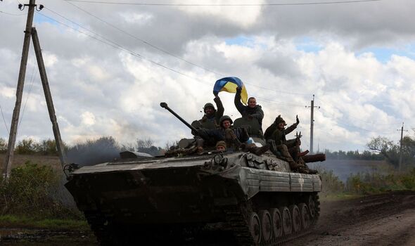 Photo de soldats ukrainiens sur un char brandissant le drapeau de l'Ukraine.