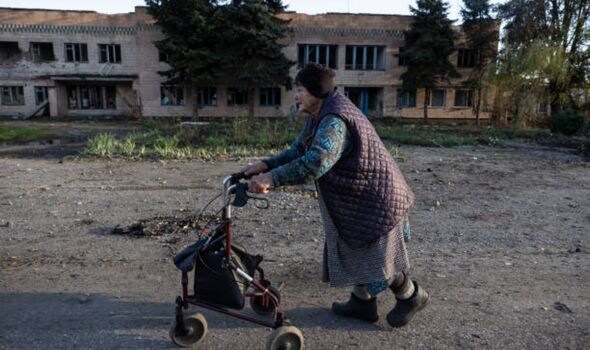 Une vieille femme pousse un chariot