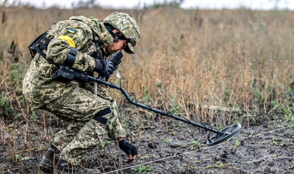 Un soldat ukrainien cherche des mines près de Kherson