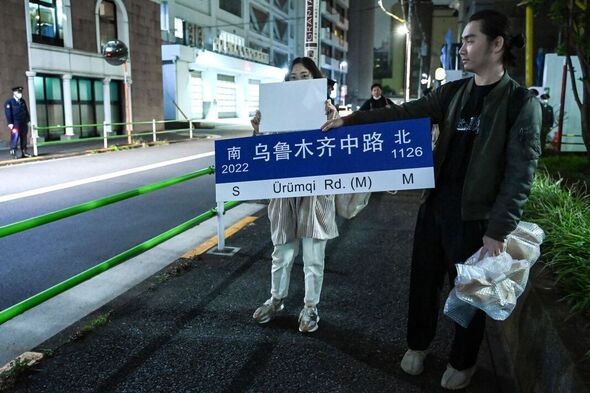 Des manifestants brandissent une pancarte devant l'ambassade de Chine