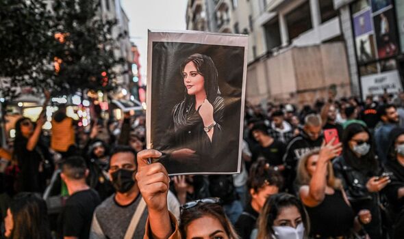 Un manifestant brandit une photo de Mahsa Amini.