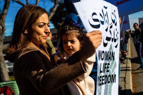 Une femme et un enfant assistent à une manifestation pour soutenir les Iraniens...
