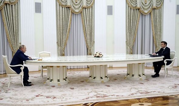 Poutine et Macron assis à une longue table à Moscou