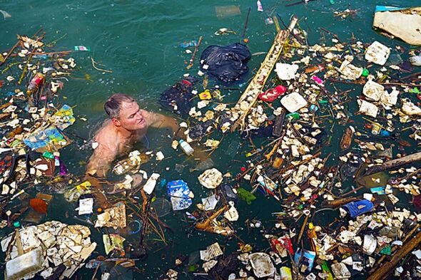 Richie Vandenberg nageant parmi la pollution plastique dans la mer en Indonésie.
