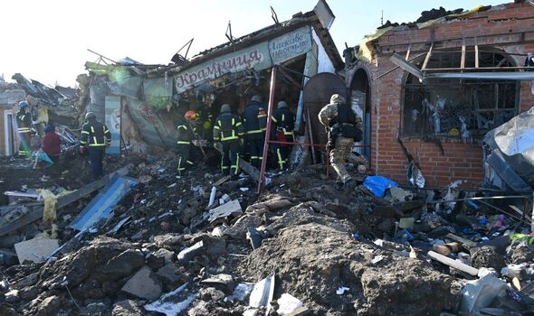 Des secouristes ukrainiens travaillent après une frappe de missile russe sur Shevchen.
