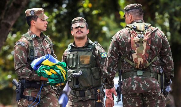 Des soldats ramassent soigneusement les drapeaux nationaux laissés par les manifestants de Bolsonaro. 