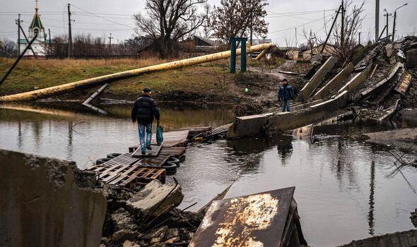 Un citoyen ukrainien de Bakhmut traverse un pont détruit le 6 janvier.