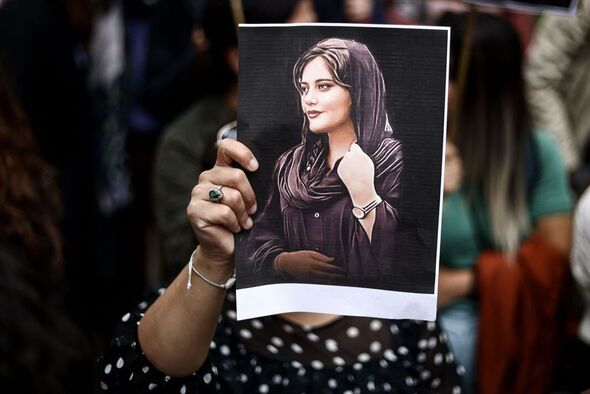 Une femme tient un poster de Mahsa Amini.