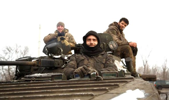 Des fantassins ukrainiens sourient à bord d'un véhicule blindé de transport de troupes