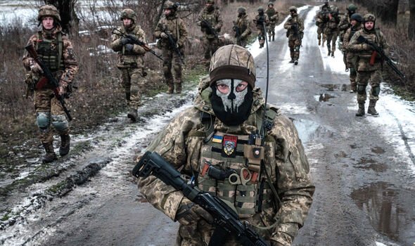 Des militaires ukrainiens marchent sur la route vers leur base près de la ligne de front dans la région de Donetsk