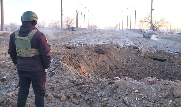Un soldat ukrainien inspecte un cratère de bombe russe dans l'ouest de Donetsk 
