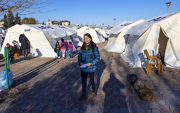 Hanna se tient au milieu des rangées de tentes