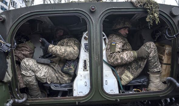 Des soldats de la marine ukrainienne sont assis à l'intérieur d'un véhicule blindé avant de se rendre à leur position sur la ligne de front à Vuhledar.