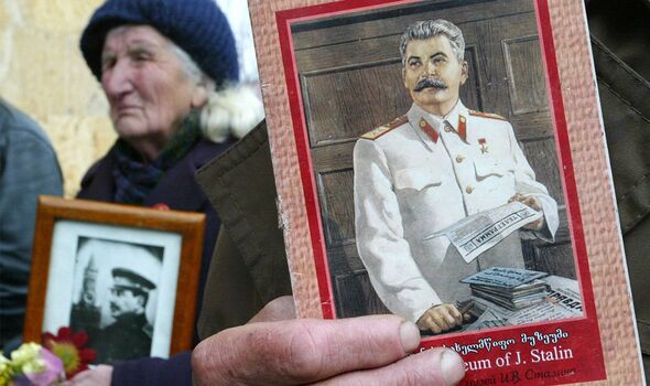 Des membres du Parti communiste géorgien tiennent des images de Staline