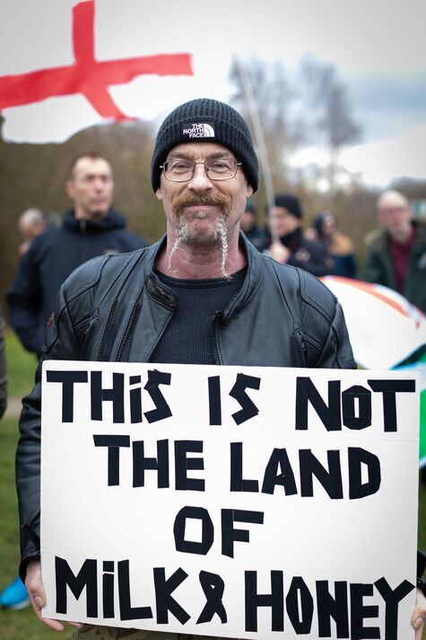 Un manifestant anti-immigration tient une pancarte devant le...