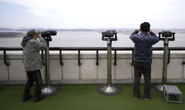 Des visiteurs utilisent des jumelles pour voir le côté nord-coréen de l'observatoire de l'unification à Paju, en Corée du Sud.