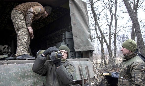 Des militaires ukrainiens déchargent des cartouches de munitions dans une position à proximité de Bakhmut