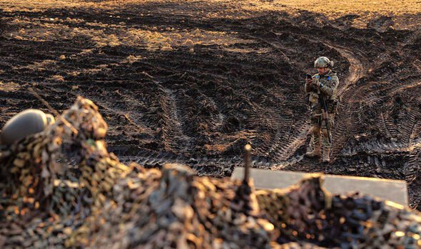 Un soldat ukrainien observe les profondes traces de boue près du front 